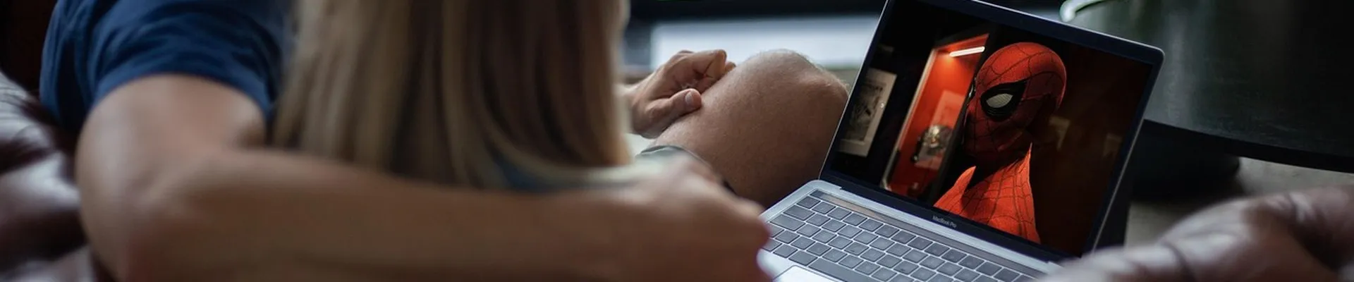 Par ser en superheltfilm sammen på en laptop i sofaen