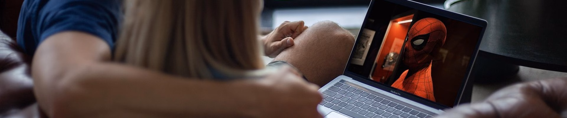 Par ser en superheltfilm sammen på en laptop i sofaen